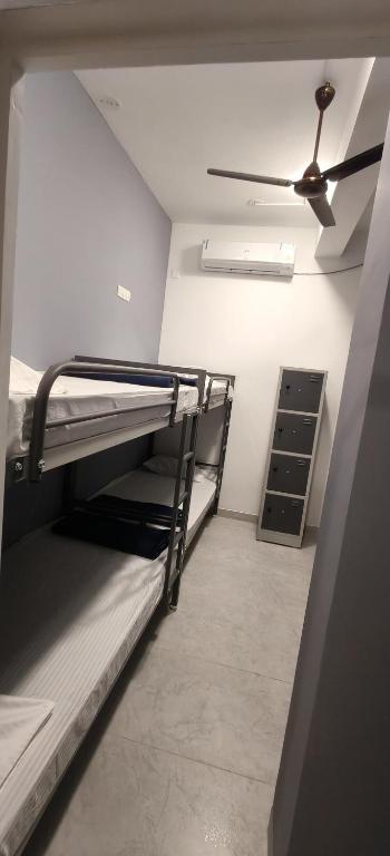 a room with two bunk beds and a ceiling fan at The Loft OMR in Chennai