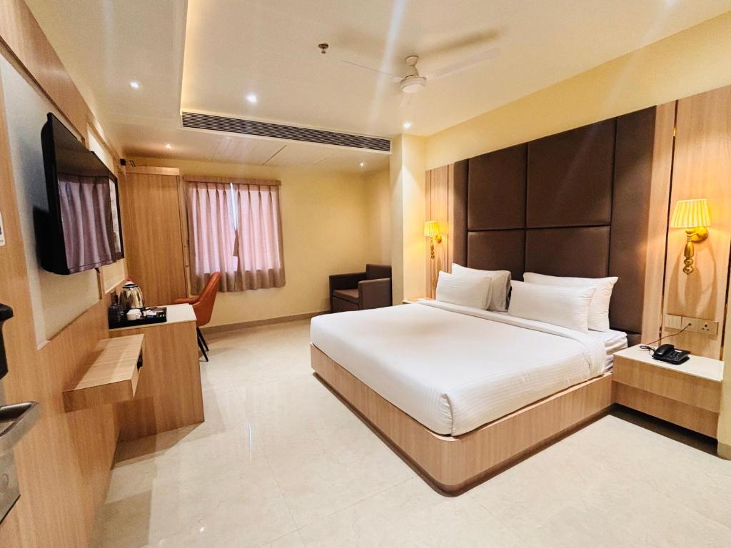 a hotel room with a bed and a television at Hotel The Elite in Jabalpur