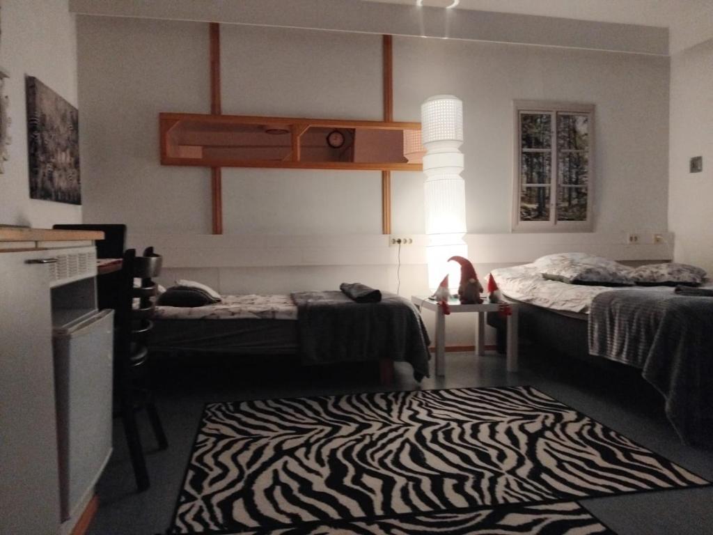 a room with two beds and a zebra print rug at Tervolahovi Lappland in Tervola