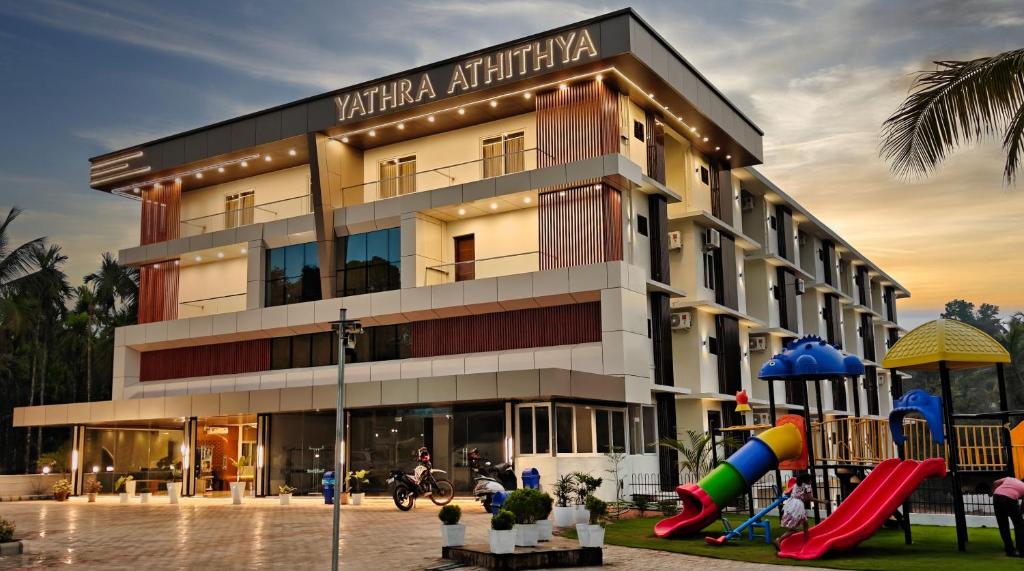 a building with a playground in front of it at Hotel Yathra Athithya in Dharmastala