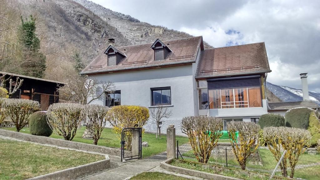 a white house with a mountain in the background at La maison Bellevue in Antignac