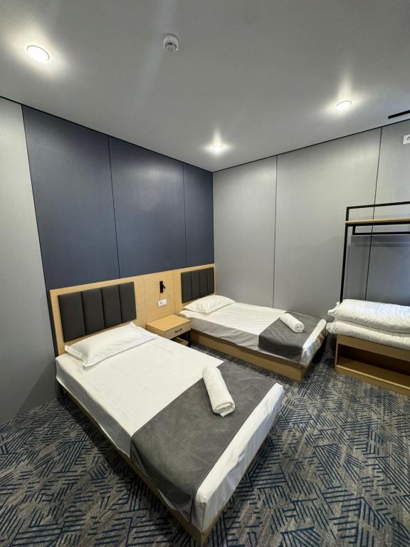 a room with two beds in a room with a wall at Home Inn Hotel in Almaty