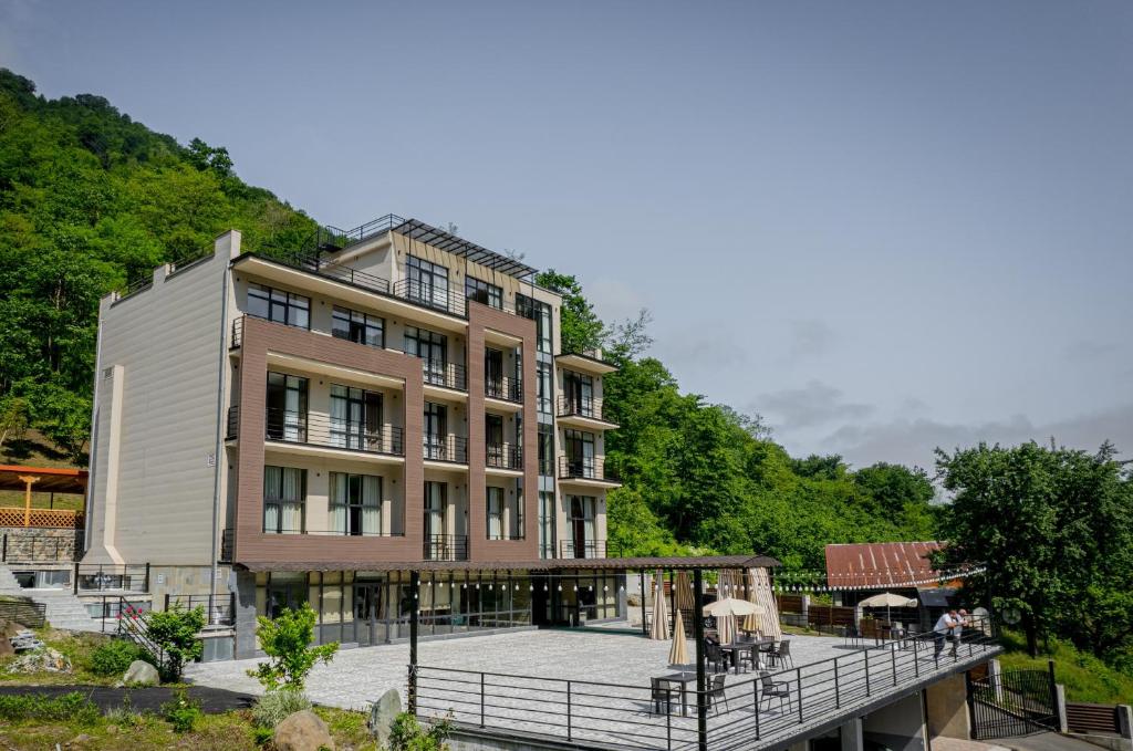 a large building with a balcony and a deck at Nabada Hotel - Riverside in Ozurgetʼi
