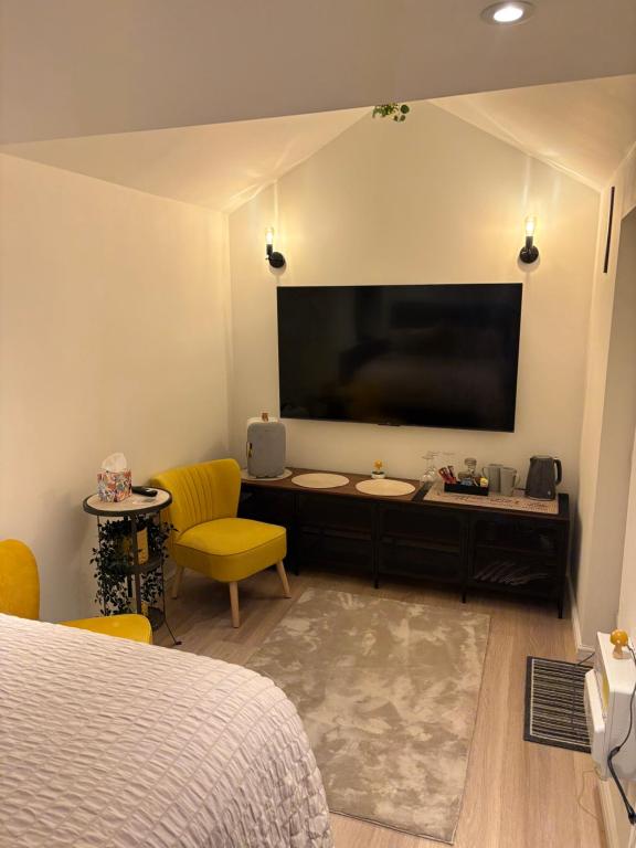 a bedroom with a large flat screen tv on the wall at The Cozy Forge in Horley