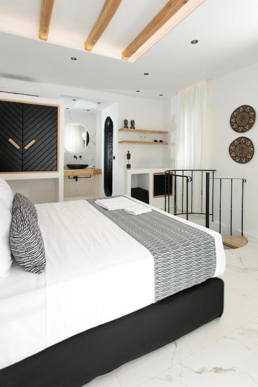 a white bedroom with a large bed in a room at Naxos Black Concept Maisonette in Naxos Chora