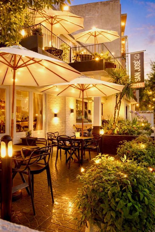 a patio with tables and chairs with umbrellas at Hotel Centro SJ in Villa Carlos Paz