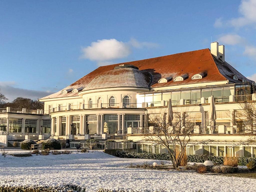 ein großes weißes Gebäude mit rotem Dach in der Unterkunft ATLANTIC Grand Hotel Travemünde in Travemünde
