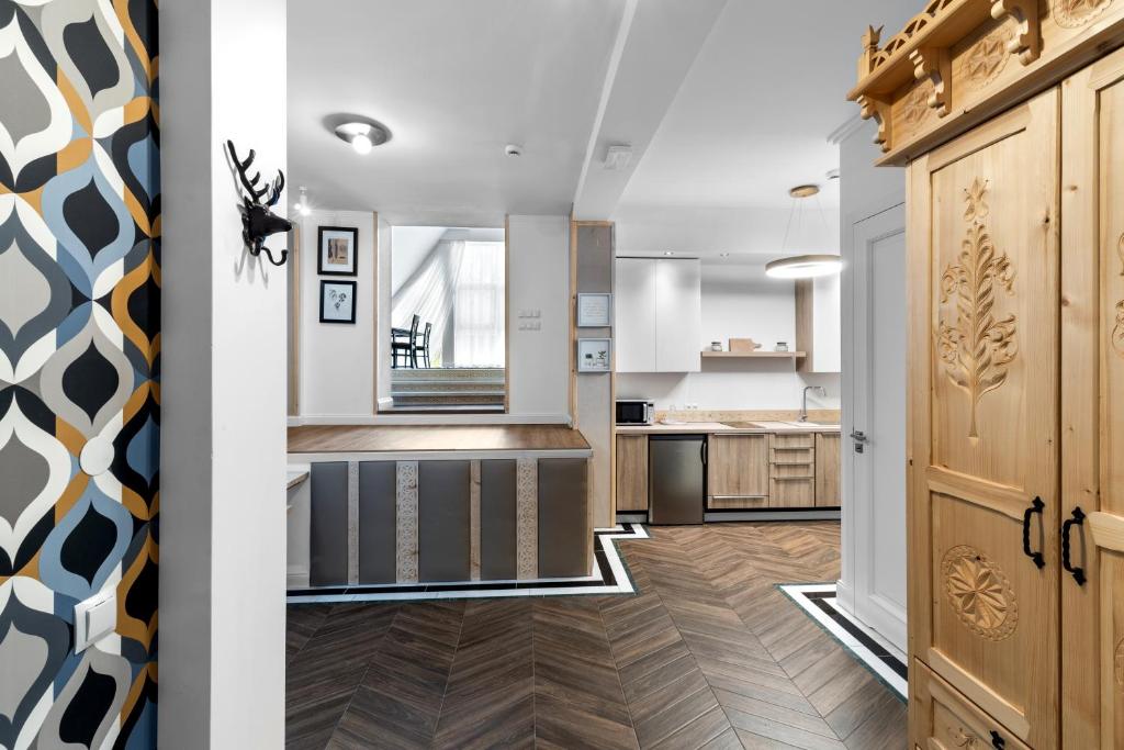 a kitchen with white walls and wooden flooring at Willa Monte in Zakopane