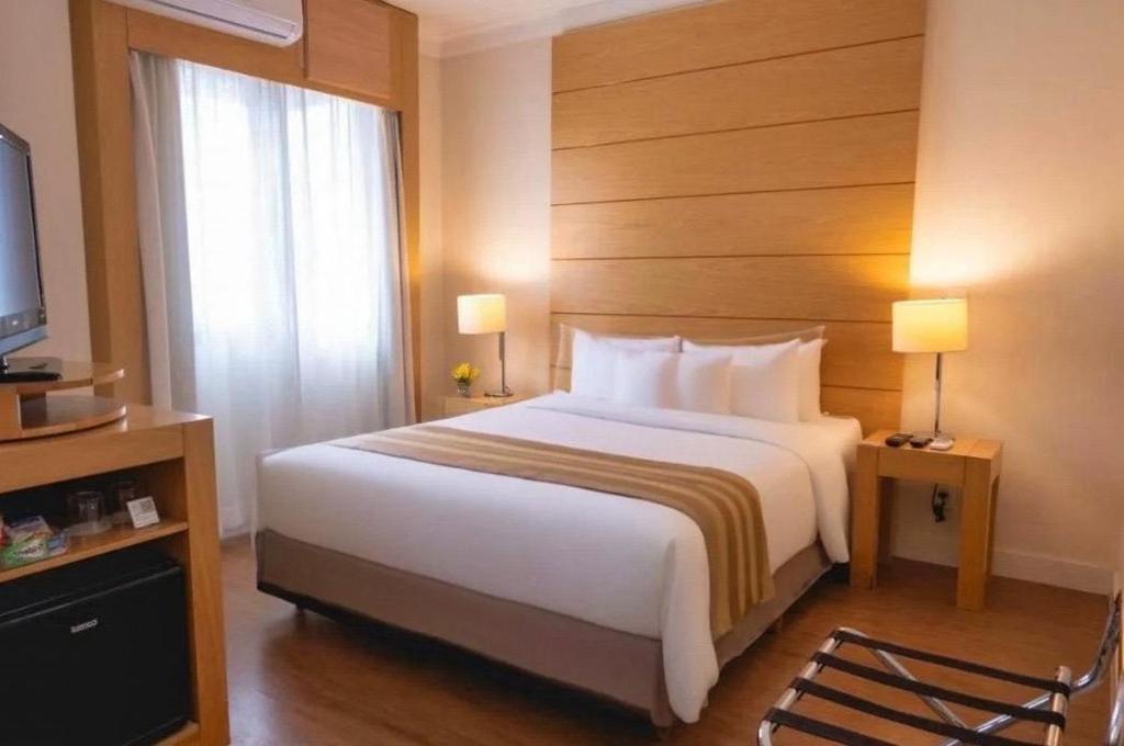 a hotel room with a large bed and a television at h604 - Flat Aeroporto Congonhas in São Paulo