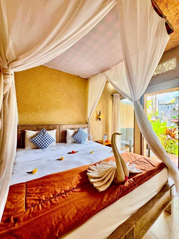 a bedroom with a large bed with a canopy at Sudi Guest House in Pemuteran