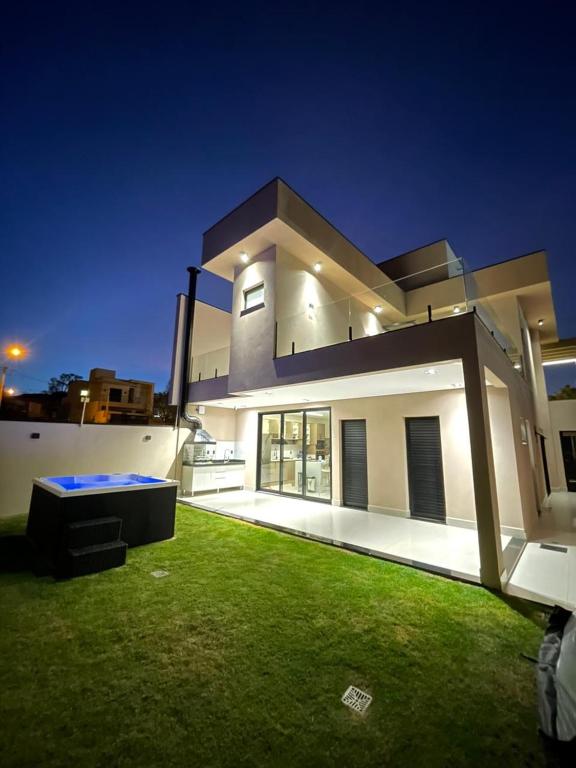 a large white house with a green lawn at night at Maison Joia dos Vinhedos in Vinhedo