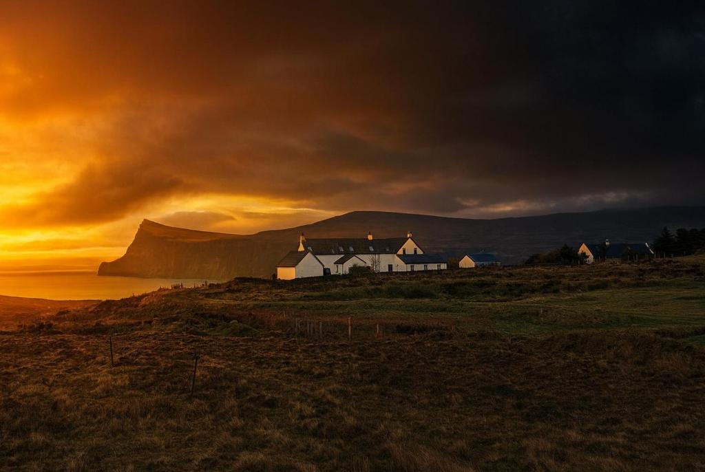 een huis op een heuvel met de zonsondergang op de achtergrond bij Lon Ban House B&B in Glendale