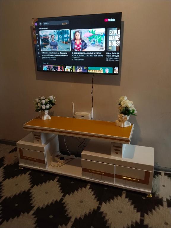 a flat screen tv hanging on a wall above a table at Staycation with Shicks in Nairobi