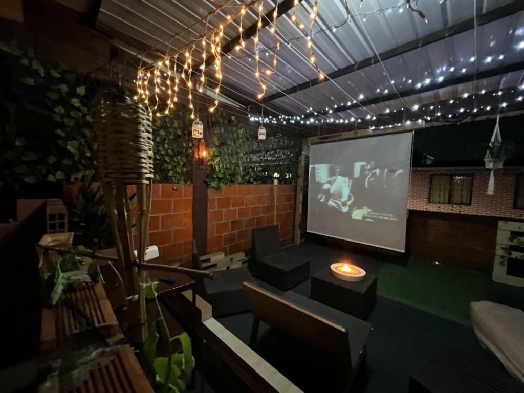 a room with a tv and a projection screen at The Magical Garden in Cali
