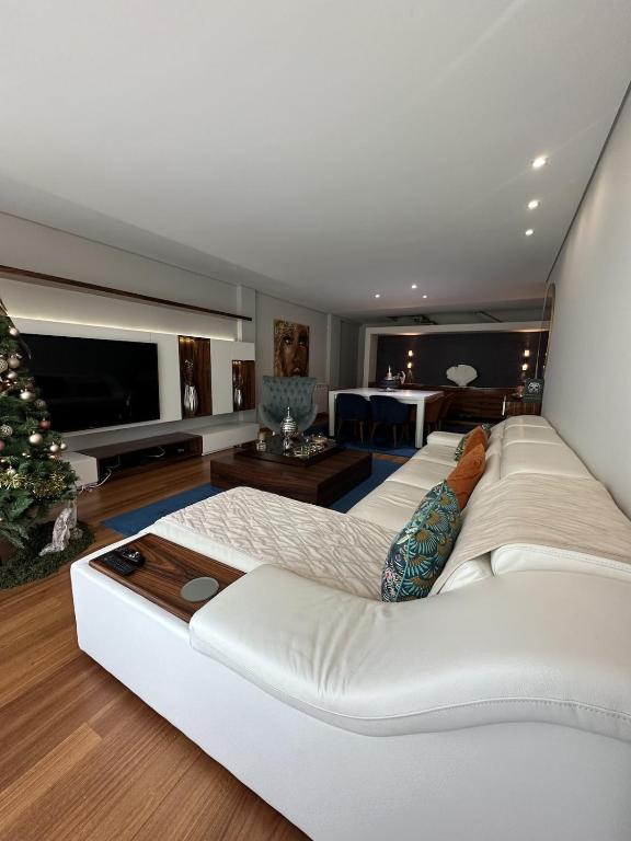 a living room with a white couch and a television at Luxury Modern Triplex Apartment in Póvoa de Varzim