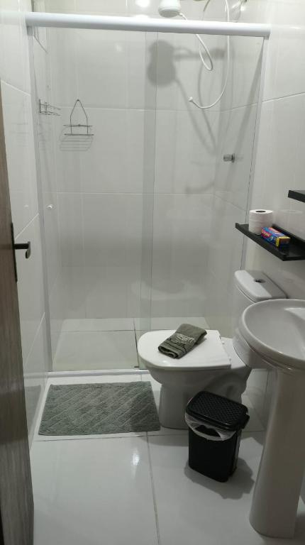 a white bathroom with a shower and a toilet at Alugo kitnet com café da manhã in Aparecida