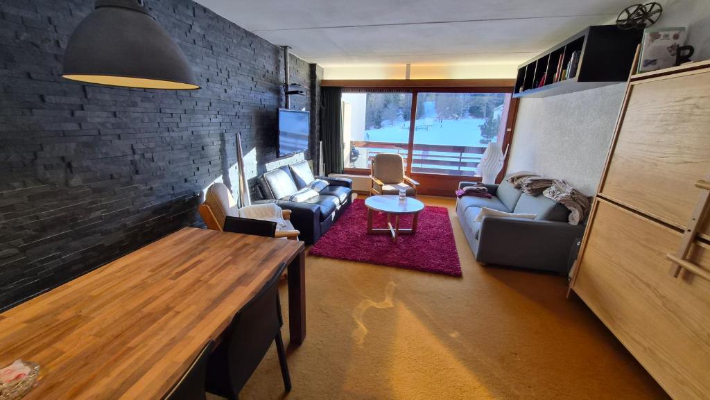 a living room with a couch and a table at 4 Valleys Ski In in Nendaz