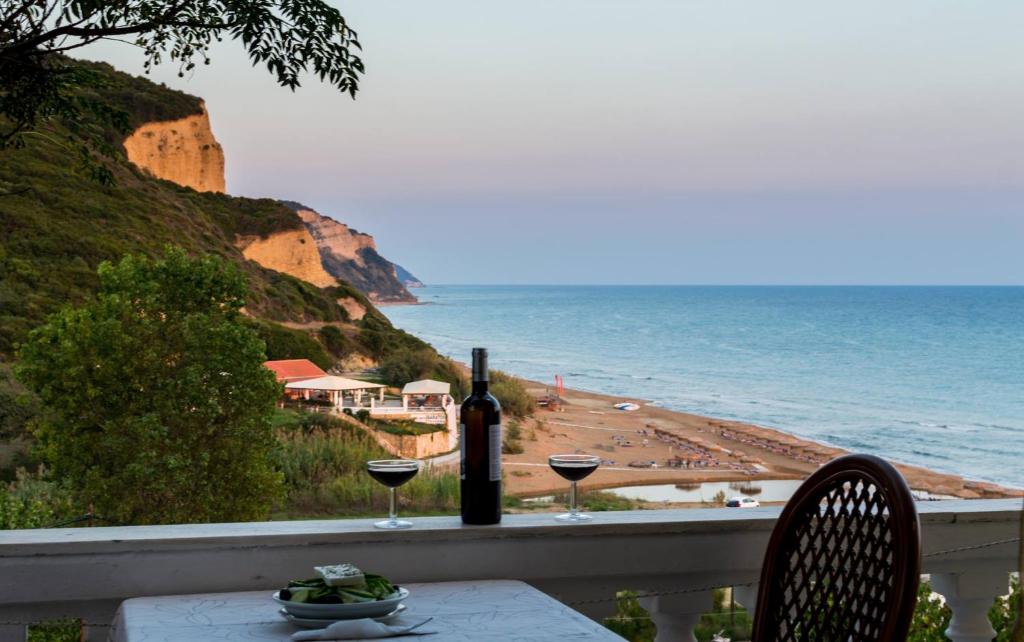 a table with two glasses of wine and a view of the ocean at Villa Kostas in Vitalades