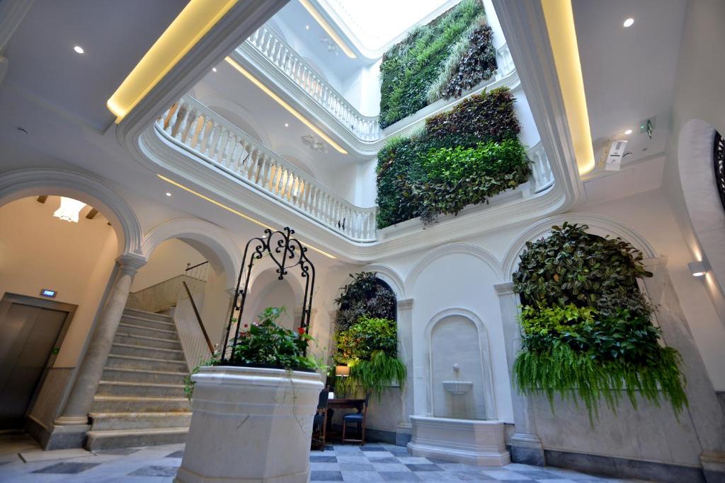 um edifício com plantas nos tectos e escadas em El Armador Casa Palacio by Luxury Suites Cádiz em Cádiz