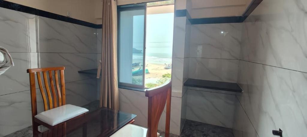 una stanza con finestra, sedia e oceano di Sea side Residency a Māvalli