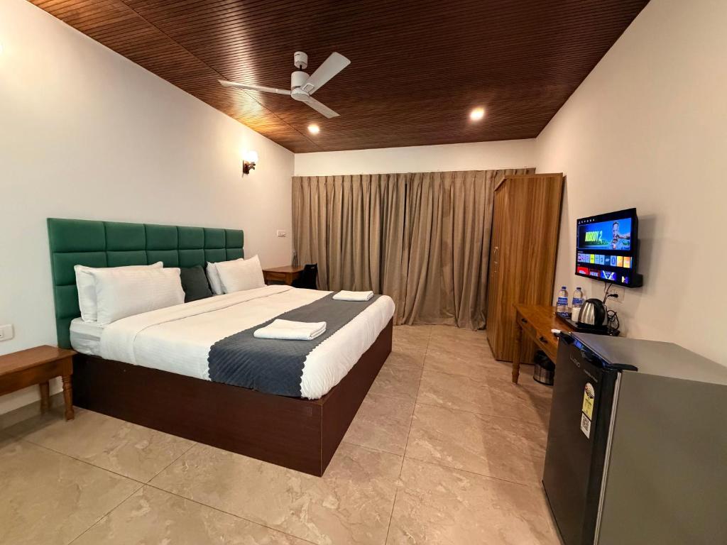 una camera da letto con un letto e una TV a schermo piatto di Orange Sky Inn a Canacona