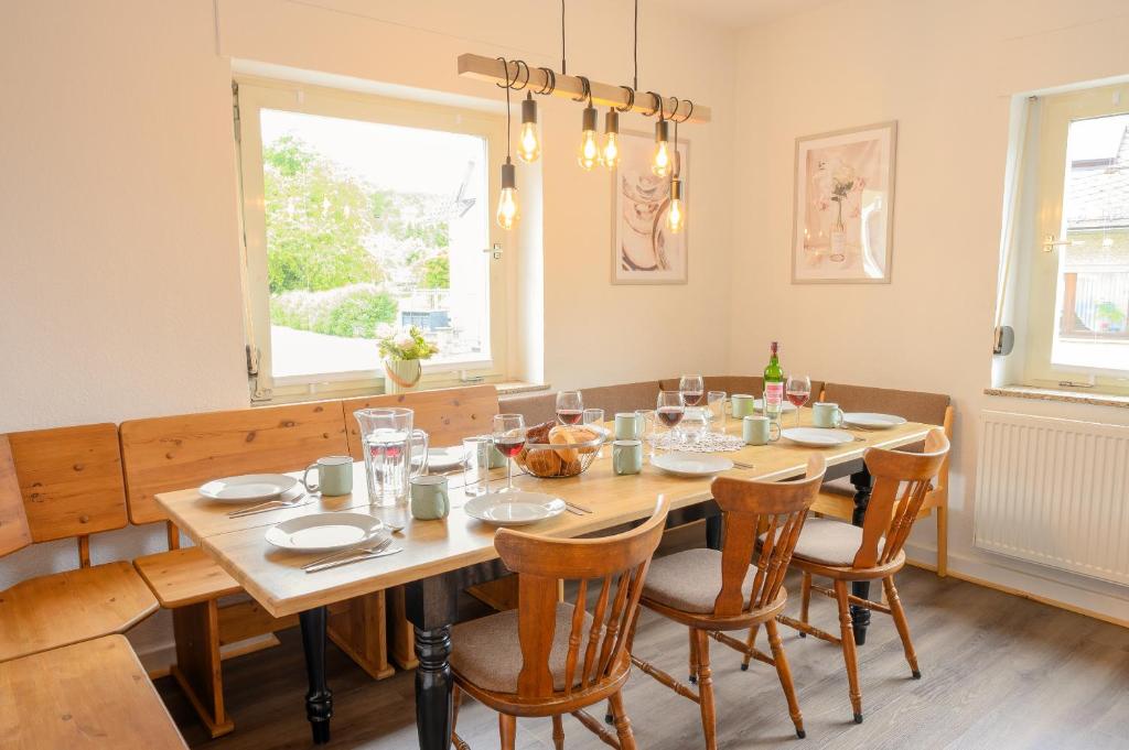 a dining room with a wooden table and chairs at Hofgut Eveshausen - Dreiseitenhof - Spielscheune - Landidylle - Hofleben in Dommershausen