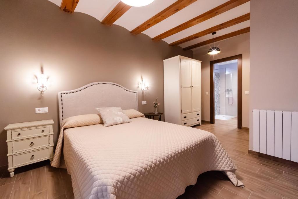 een slaapkamer met een wit bed en een houten vloer bij Encanto de Valderrobres in Valderrobres