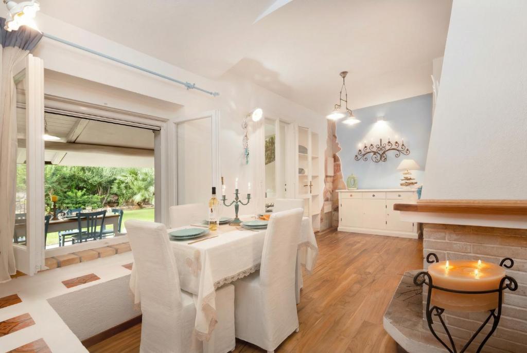 una sala da pranzo con tavolo e sedie bianchi di Villasimius - Villa Sofia a San Stèfano