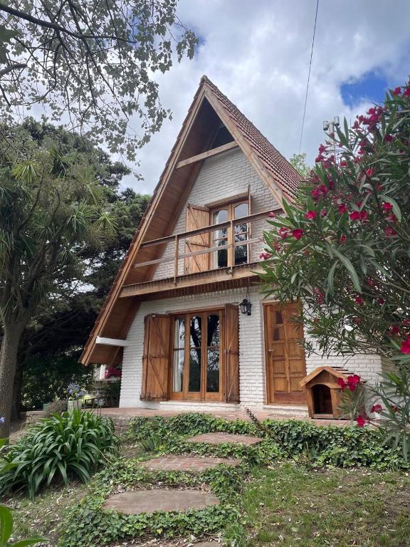a house with a wooden door and a tree at Welpen Chapa in Mar del Plata