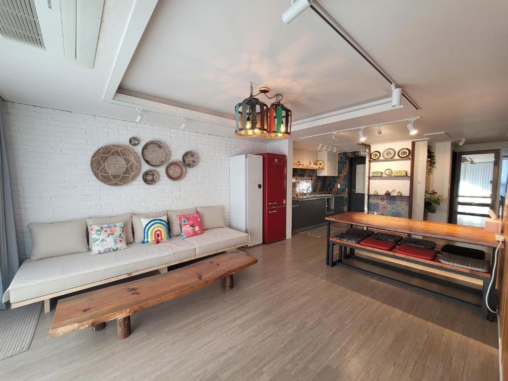 a living room with a couch and a table at Red Casa in Seogwipo
