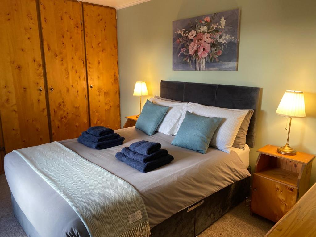 una camera da letto con un letto con asciugamani blu sopra di Foxs Farmhouse a Ballinrobe
