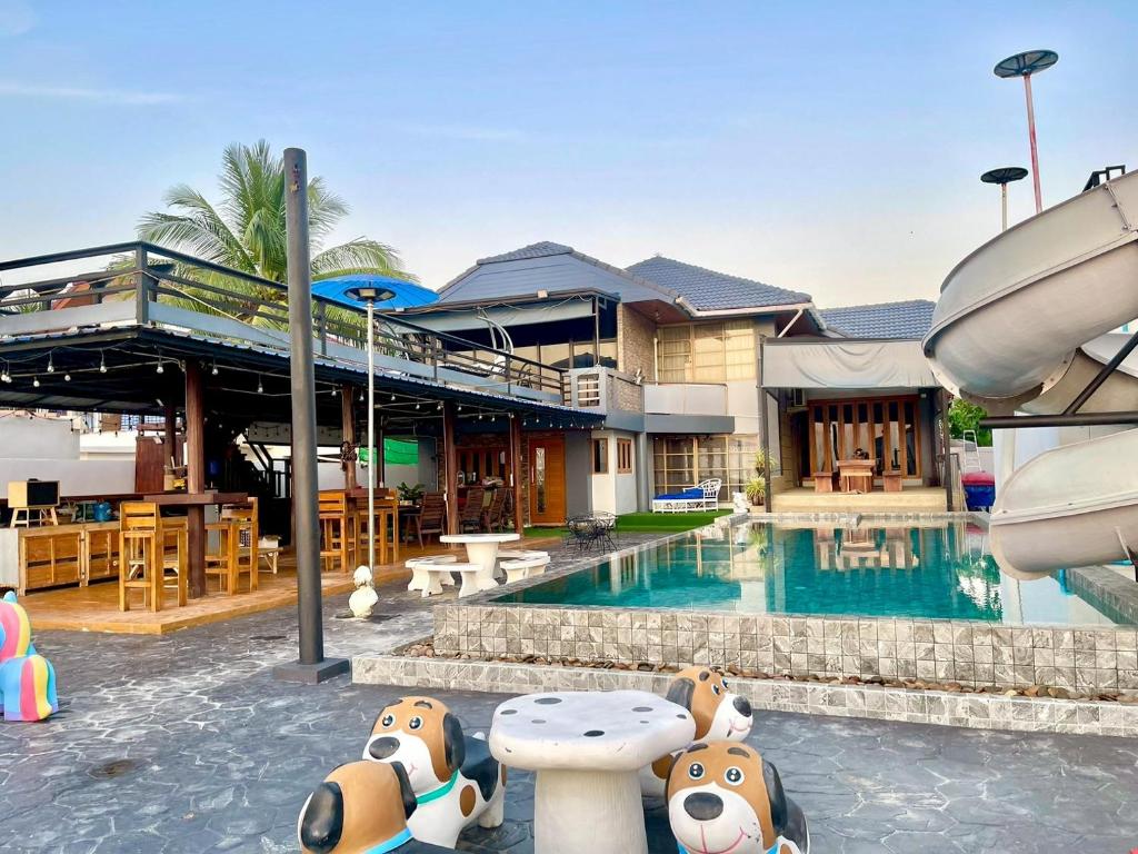 a resort with a pool with stuffed animals sitting next to it at บ้านดาริน บีช Baan Darlin Beach in Phetchaburi