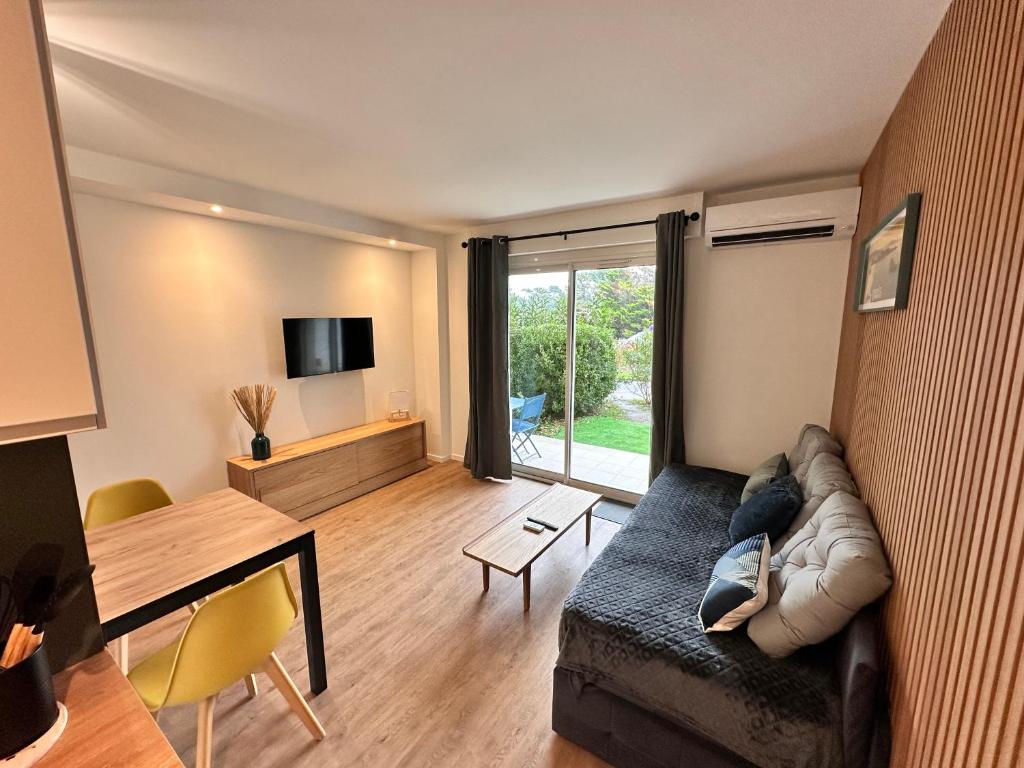 een woonkamer met een bank en een tafel bij Ocean et Golf in Anglet