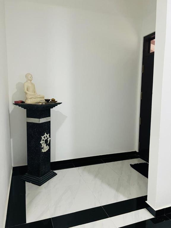 a statue sitting on a pedestal in a room at moonlight villa in Weligama