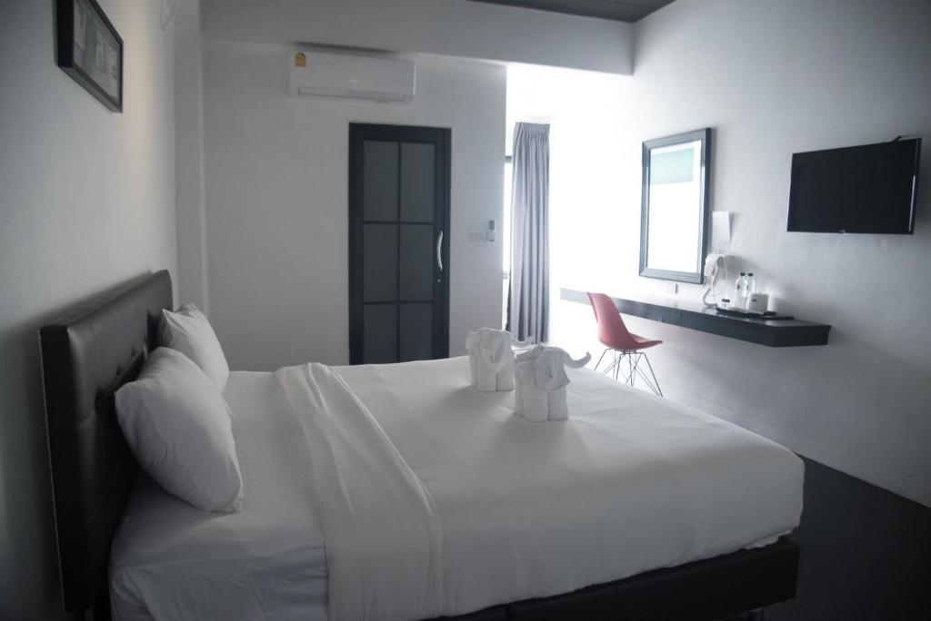 A double room with a wall-mounted television, window-side desk and large bed.