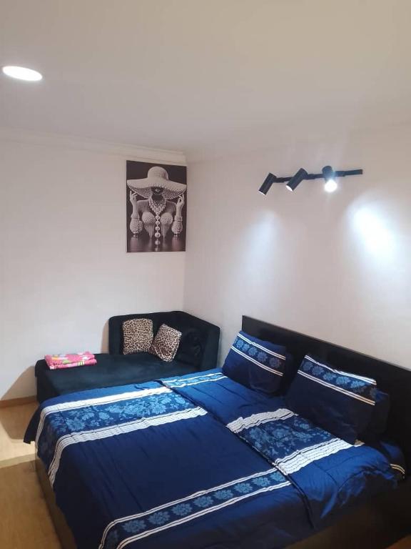 a bedroom with two beds and a couch at Short Let Apartments in Lagos Business School Lekki Ajah in Lekki