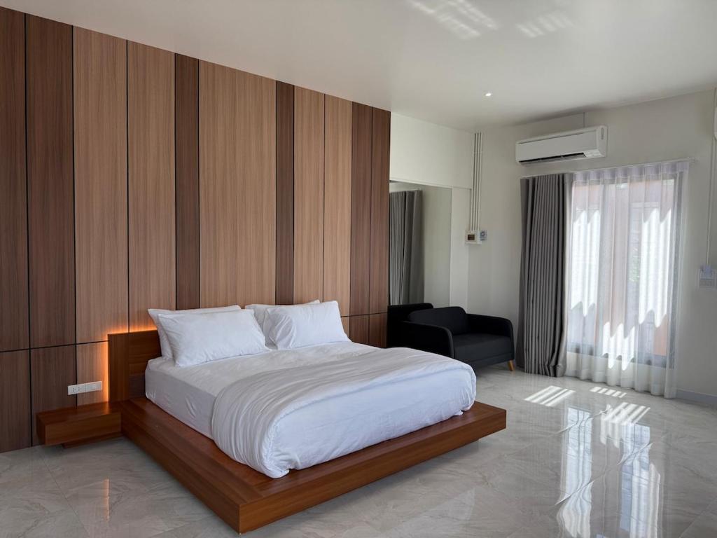 a bedroom with a bed and a chair in it at Booze room in Ban Khlong Chi Lat