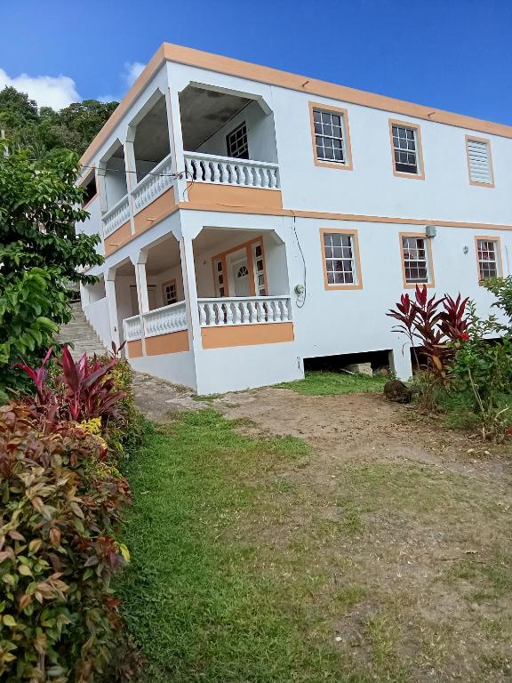 een groot wit huis met een tuin bij Cassiane apartments in Thibaud