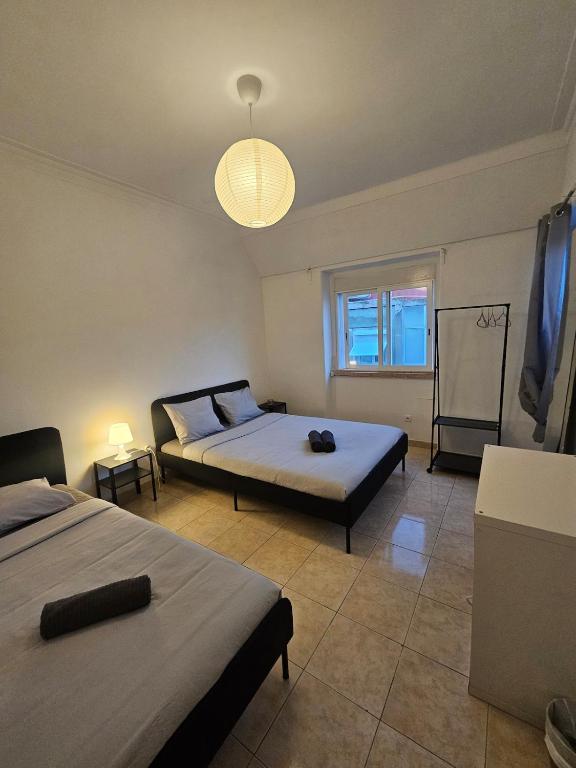 a bedroom with two beds and a window at spacious guest rooms in Lisbon