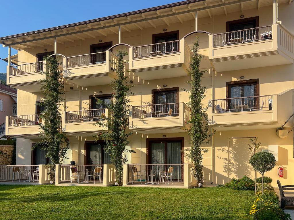 a building with balconies and a green lawn at Valentinos House in Parga