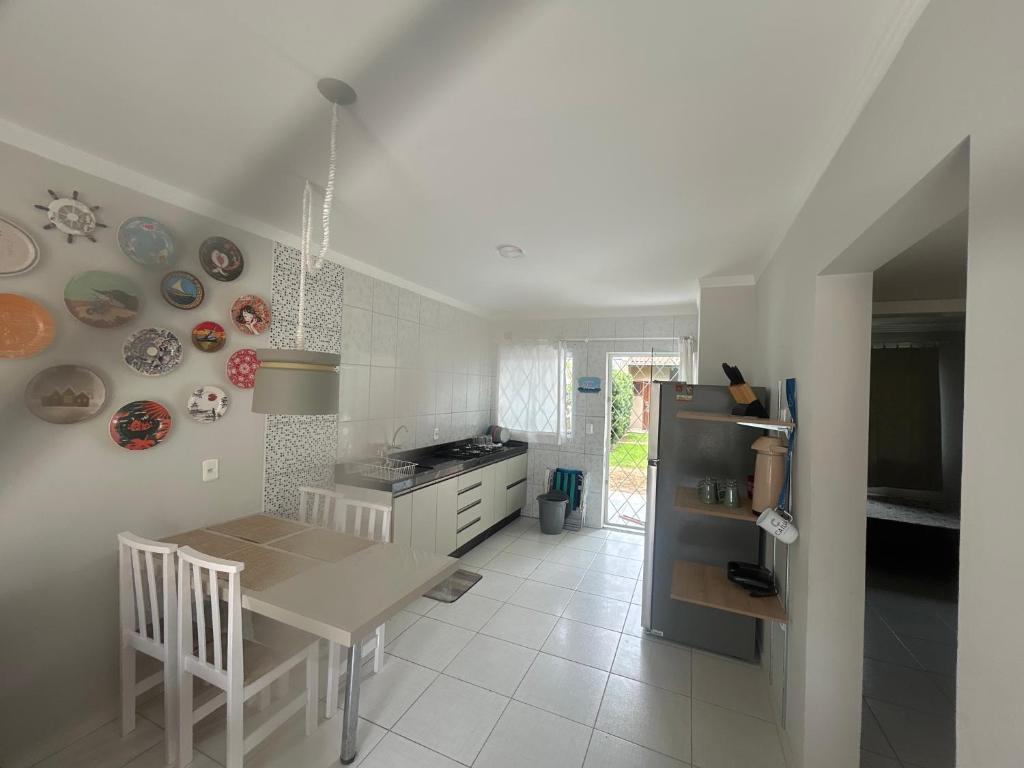 een keuken met een tafel en een koelkast. bij Casa de praia in Barra Velha