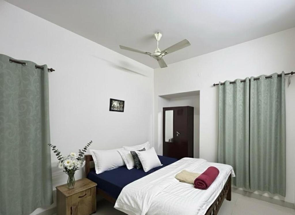 a bedroom with a bed and a ceiling fan at Dream Nest Beach House in Alleppey