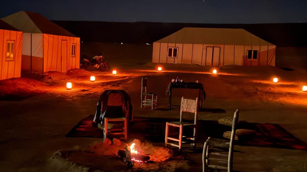 a room with two chairs and a table and some lights at Iriki Desert Camp Foum Zguid in Foum Zguid