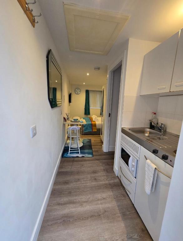 a small kitchen with a sink and a stove at The Cosy Pod Studio - Short Stay in Salford in Manchester