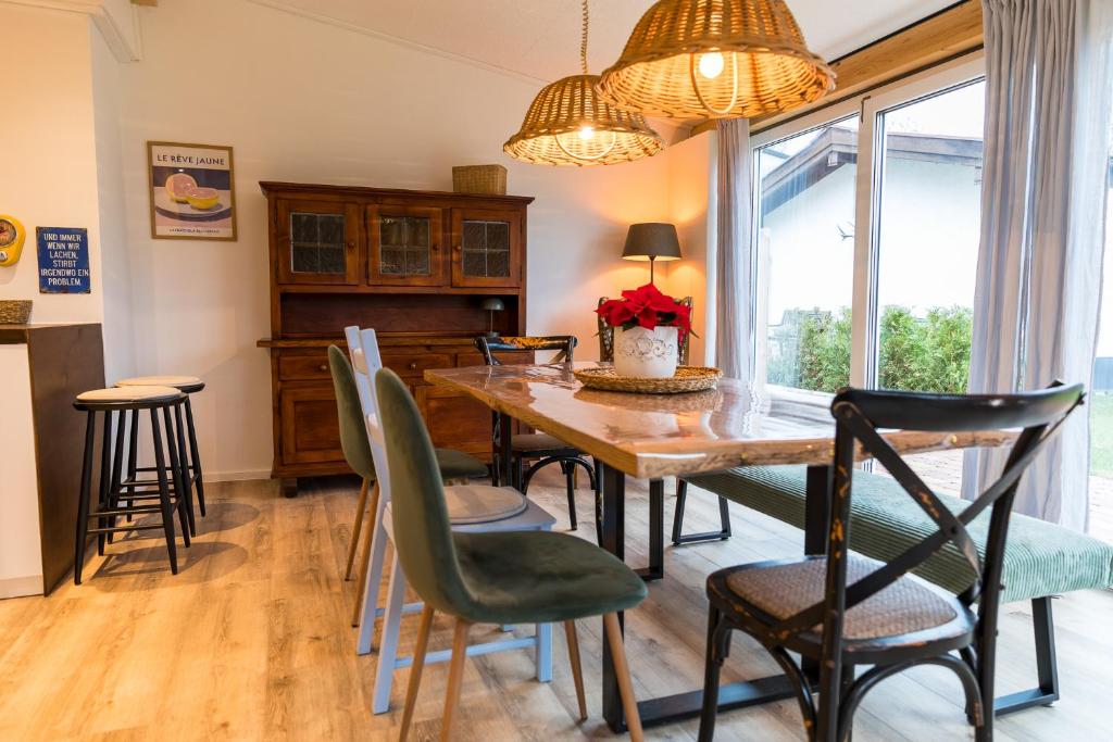 a dining room with a wooden table and chairs at Ferienhaus am Eichberg in Grabenstätt