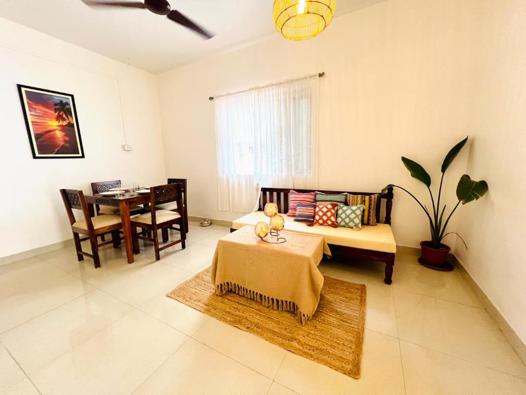 een woonkamer met een bank en een tafel bij White House Stay in Patnem