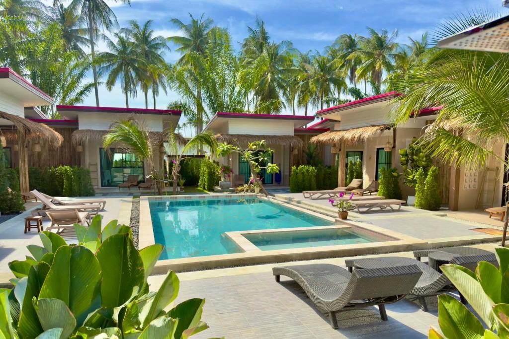 a villa with a swimming pool and palm trees at Pinky Bungalows Resort & Villa in Ko Lanta