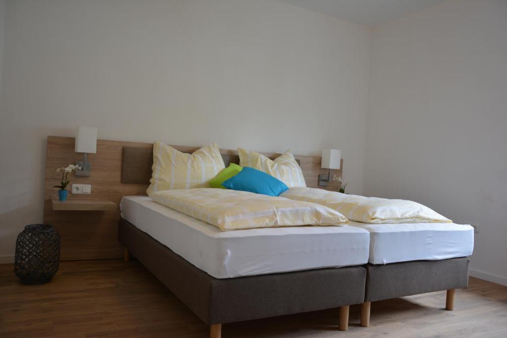 łóżko z białą pościelą i poduszkami w obiekcie Zur Lahnbrücke w mieście Caldern