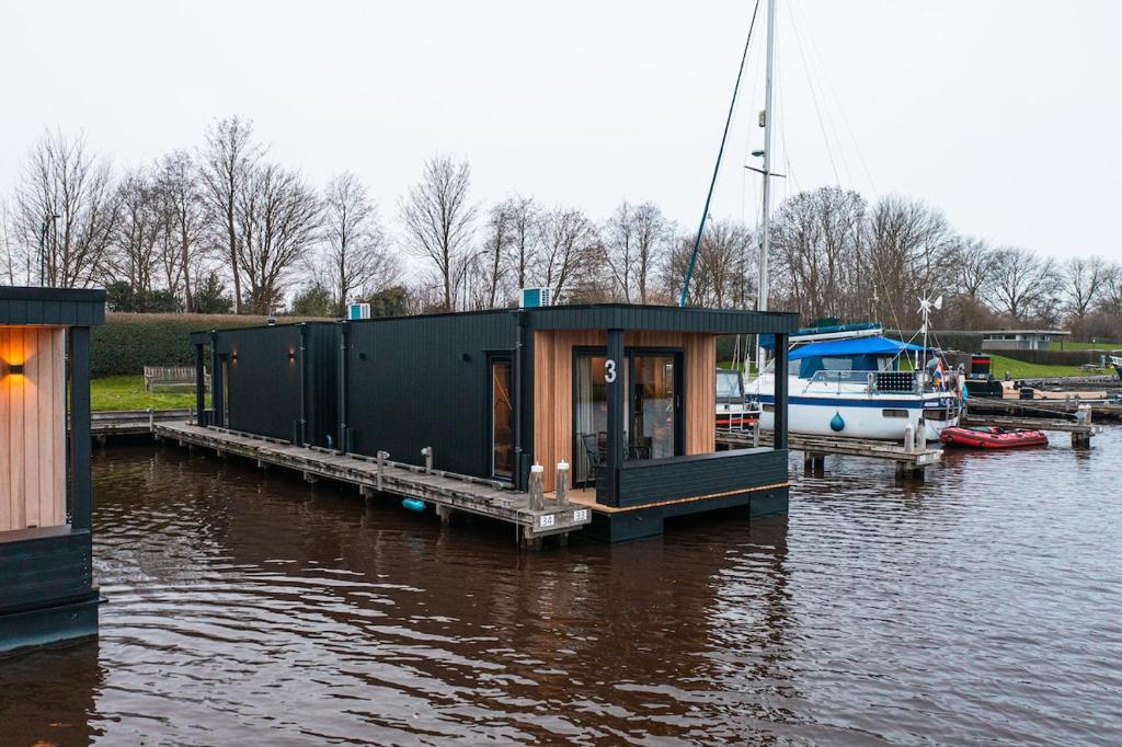 a small house on a dock on a body of water at Tiny Boat House #5 in Garnwerd