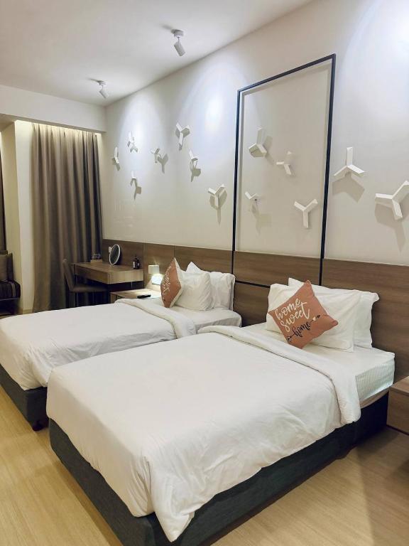 two beds in a hotel room with birds on the wall at Windmill Upon Hills Genting Highland by El Naura in Genting Highlands